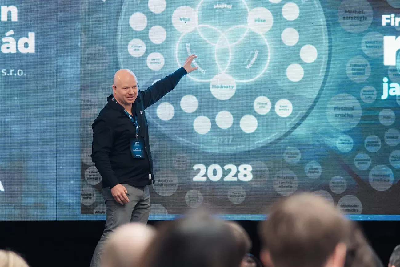 CEO eBRÁNY Martin Semerád vysvětluje celostní přístup k řízení firmy před velkou LED stěnou.