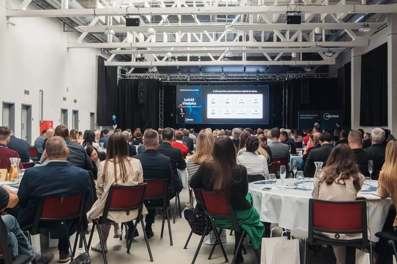 Pohled na zaplněný sál s účastníky konference eBRÁNA sledujícími přednášku.